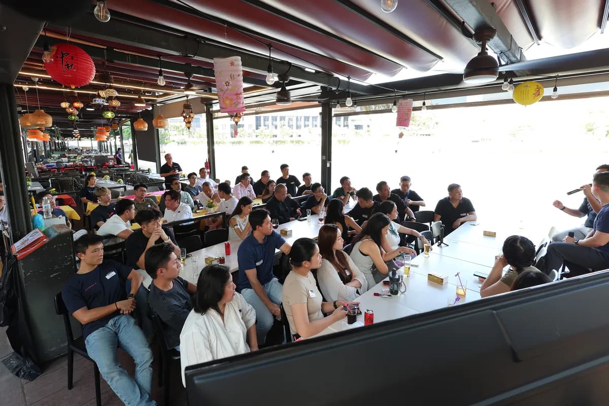 Singapore community attendees seated around tables listening to a speaker