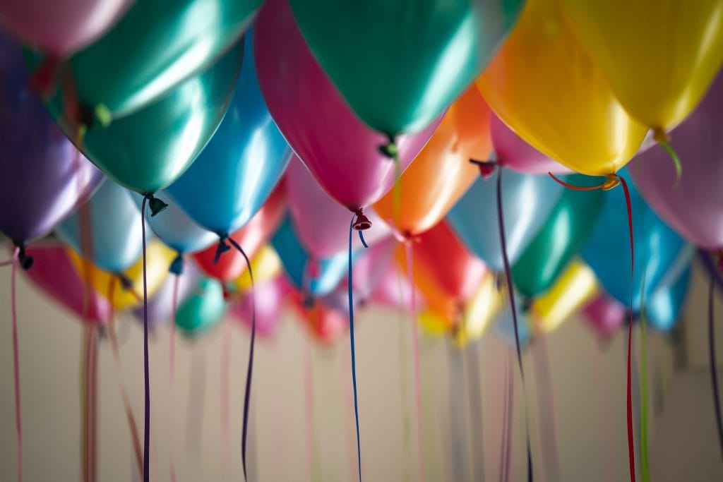 a bunch of colourful helium balloons on the ceiling