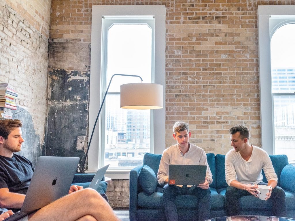 co-workers completing their peer review on their laptops