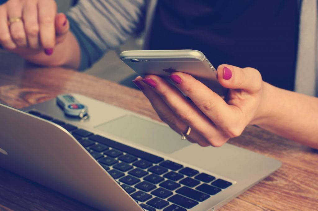 a technology-savvy employee using her phone and laptop